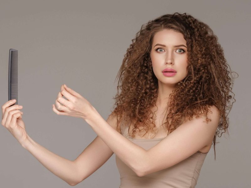 Hair loss woman brushing curly hairstyle healthy care