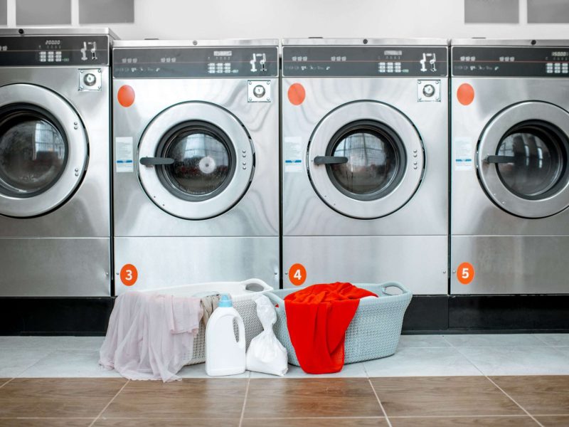Professional washing machines with baskets full of clothes at the self-service laundry